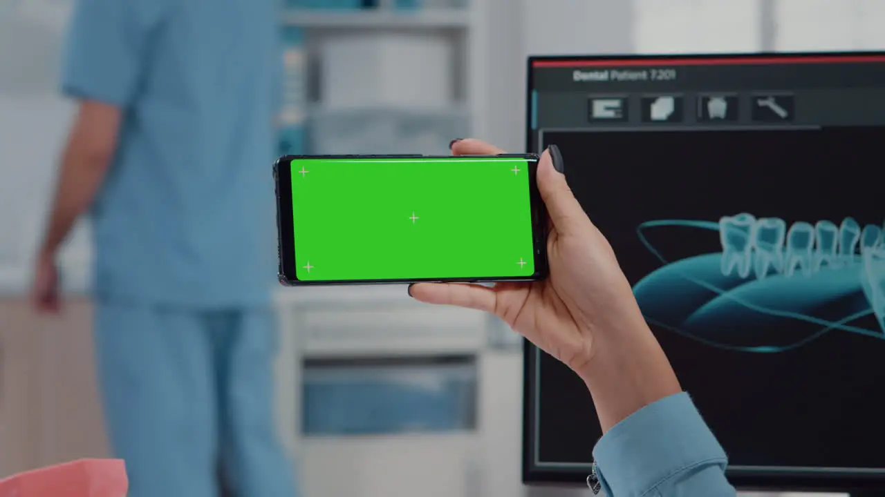 Close up of orthodontist holding horizontal green screen