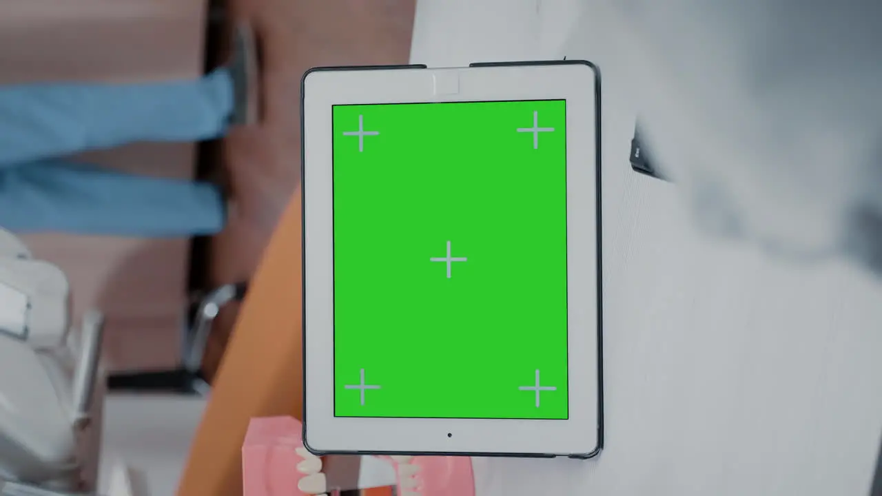 Vertical video Close up of dentist using green screen on tablet