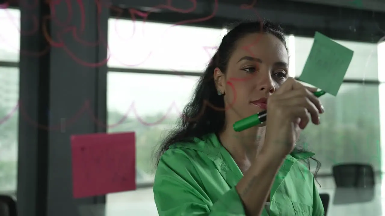 Young hispanic employee writing on colorful sticky notes Closeup Manipulator