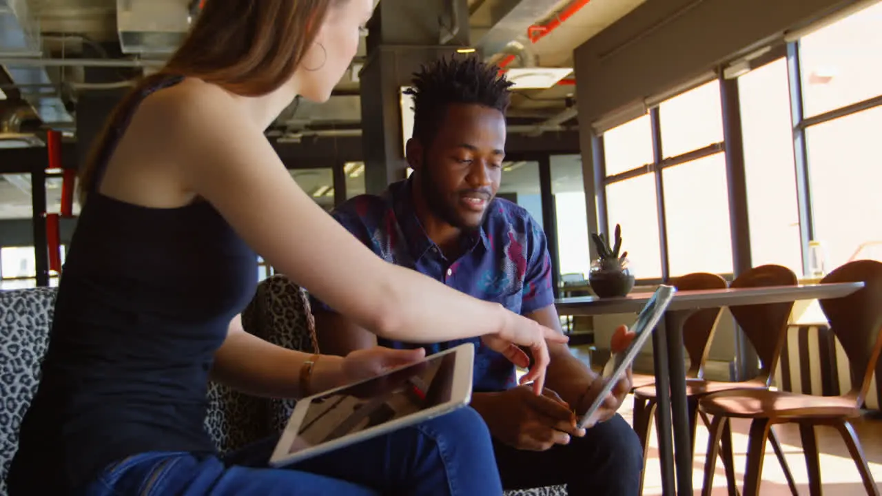 Side view of young cool mixed-race business team planning and sitting on couch of modern office 4k