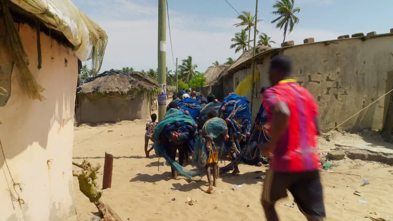 Group of African people transporting fishnets in a village in Ghana