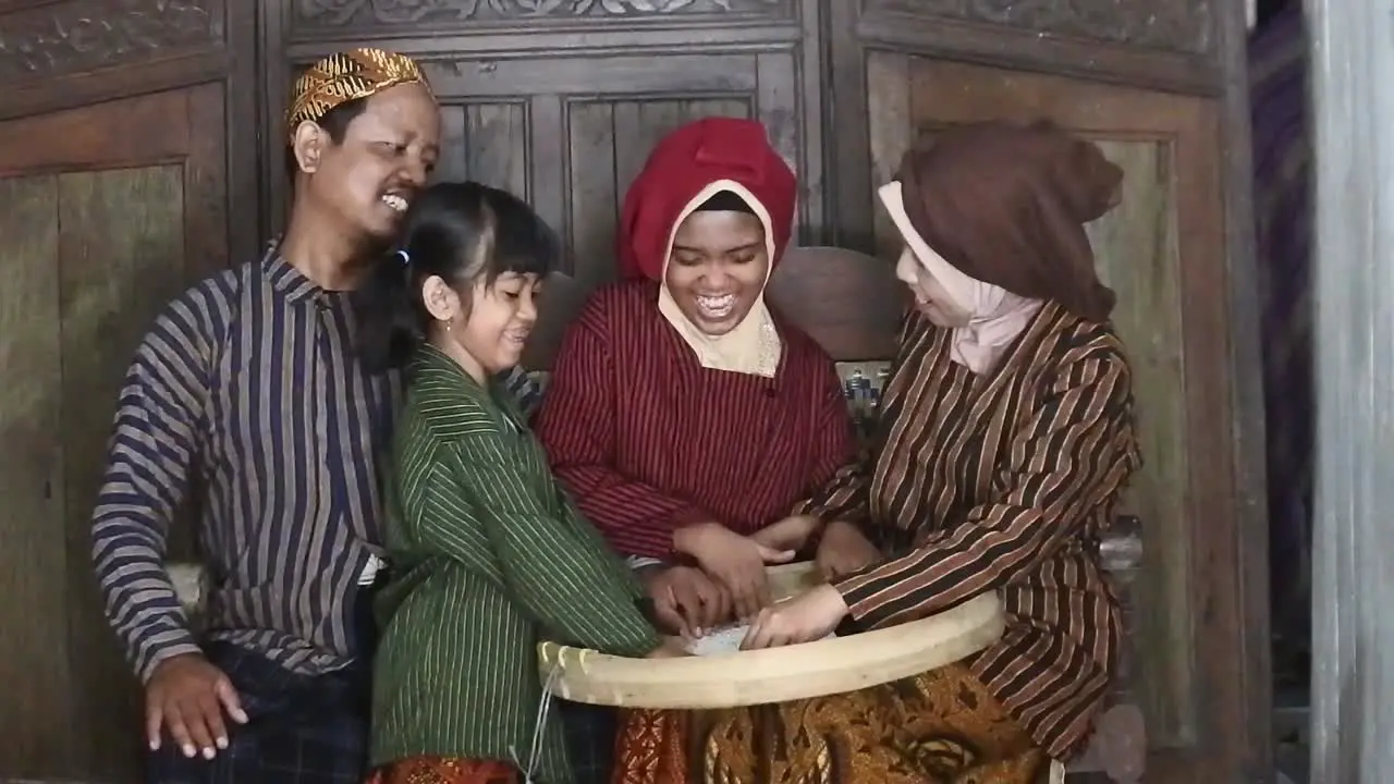 A happy Javanese family with their two children with a tray of rice Central Java Indonesia