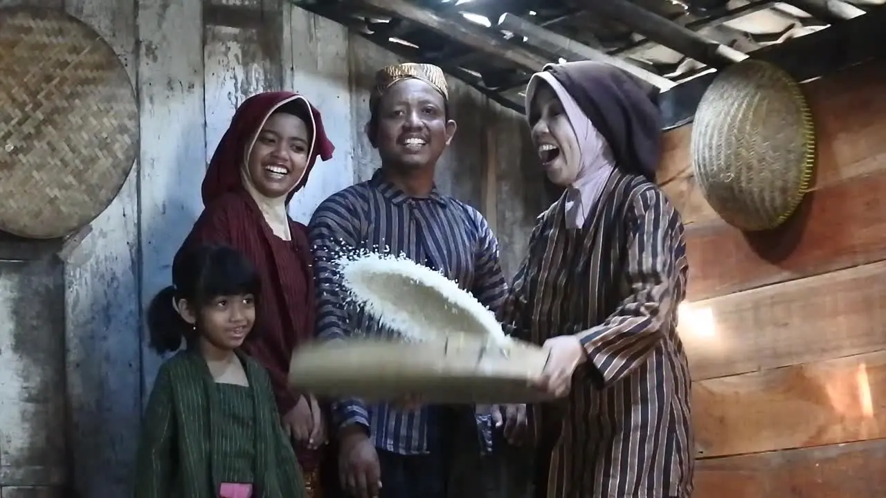 A happy Javanese family with their two children with a tray of rice Central Java Indonesia_slow motion