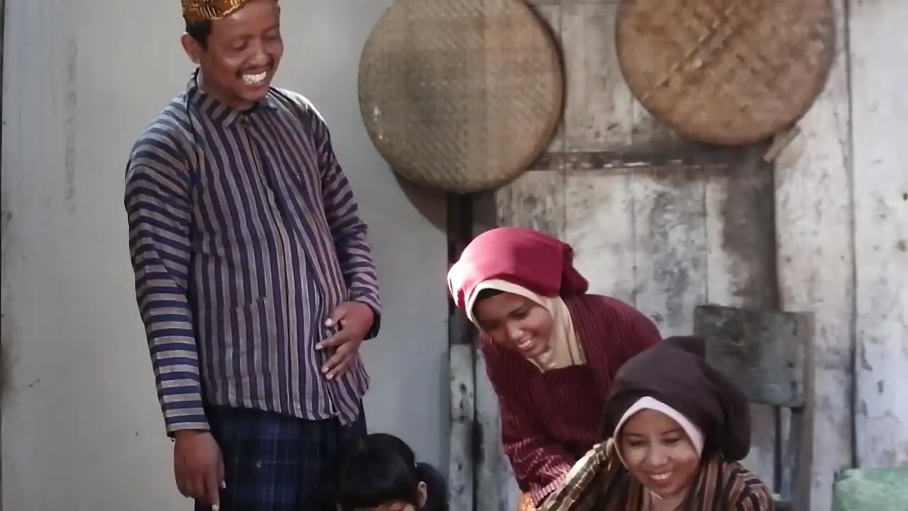 Happy Javanese family with their two children in front of an ancient kitchen Central Java Indonesia_tilt up shot