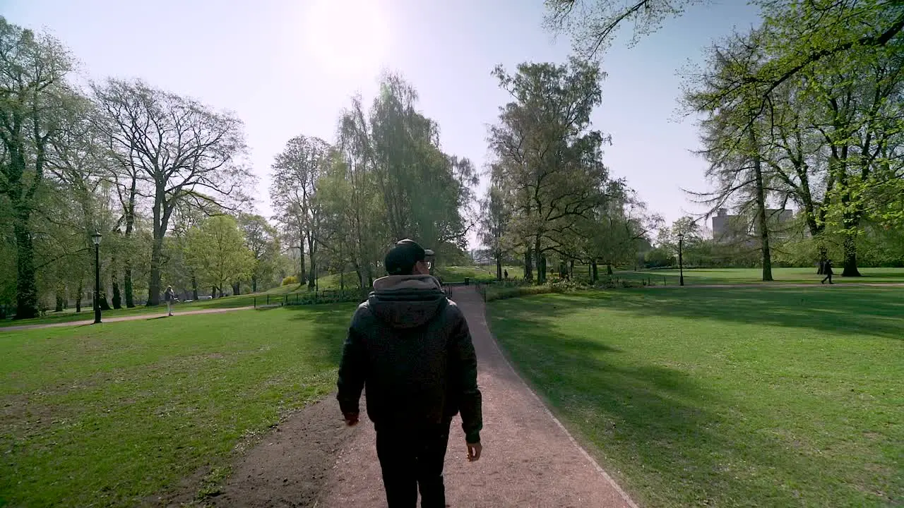 Gimbal shot of Tourist walking around the park at the Royal Palace of Oslo Norway