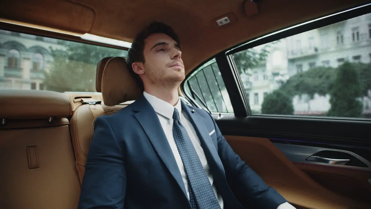 Tired business man resting at back seat of modern car Businessman relaxing