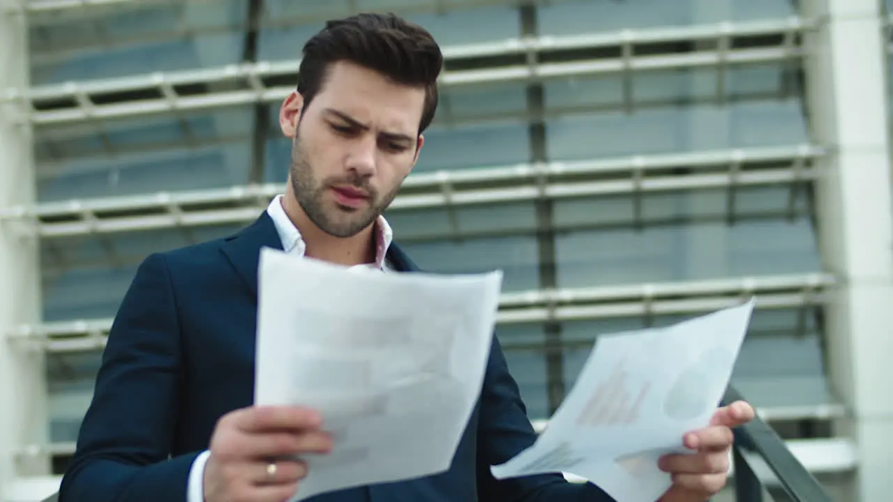 Portrait businessman looking at papers Man standing with documents outside