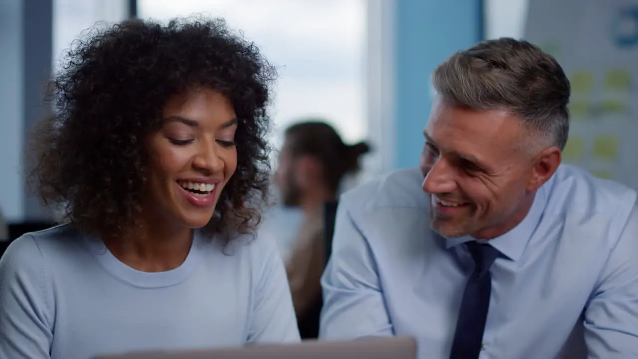 Smiling businesswoman and businessman looking at good work results in office