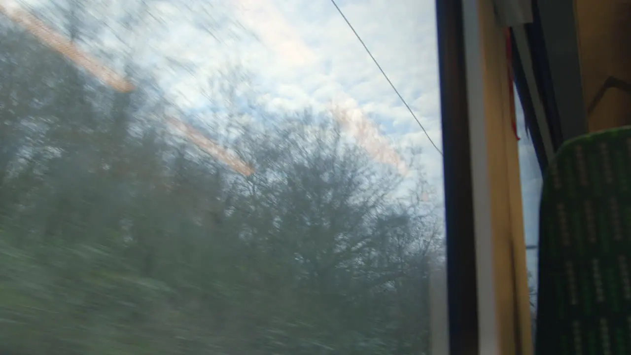 Looking out at sky from moving train exiting tunnel