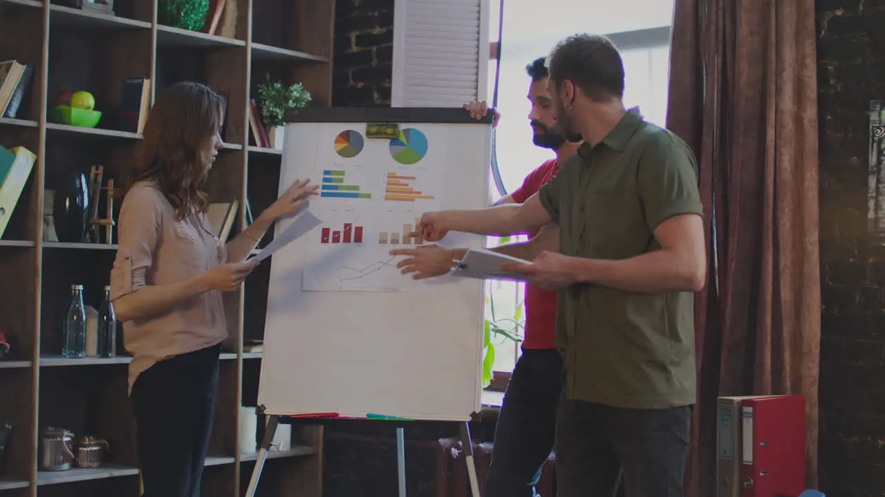 Young business people argue about business plan on white board in office