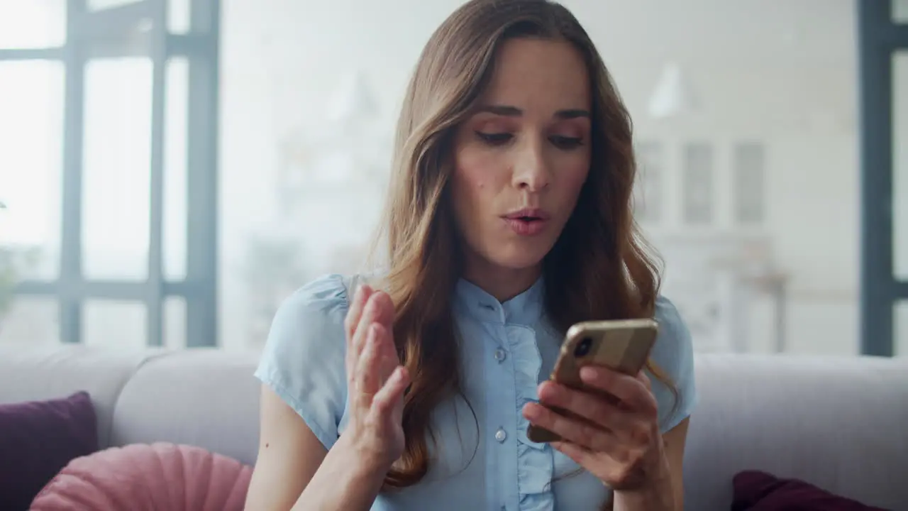 Business woman reading good news on phone on couch Girl chatting on phone