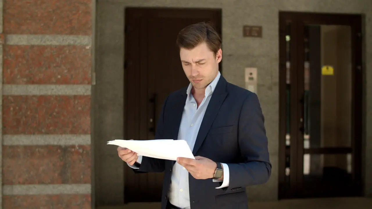 Closeup man reading documents Businessman looking at documents at street