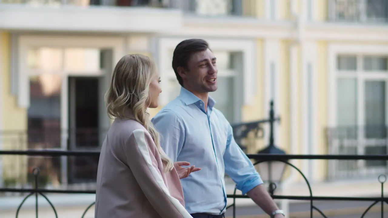 Smiling business couple walking at street Business partners talking outside