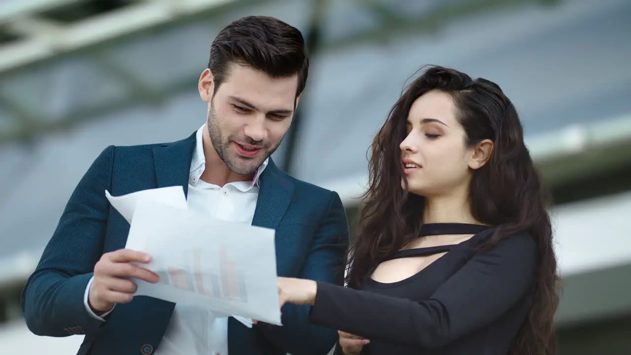 Closeup business partners reading documents Couple discussing project outside