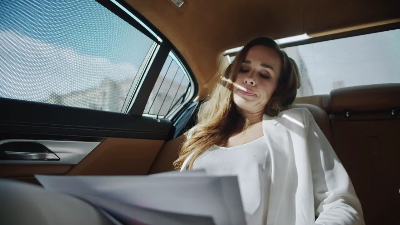 Tired business lady reviewing data in car Woman reading documents in automobile