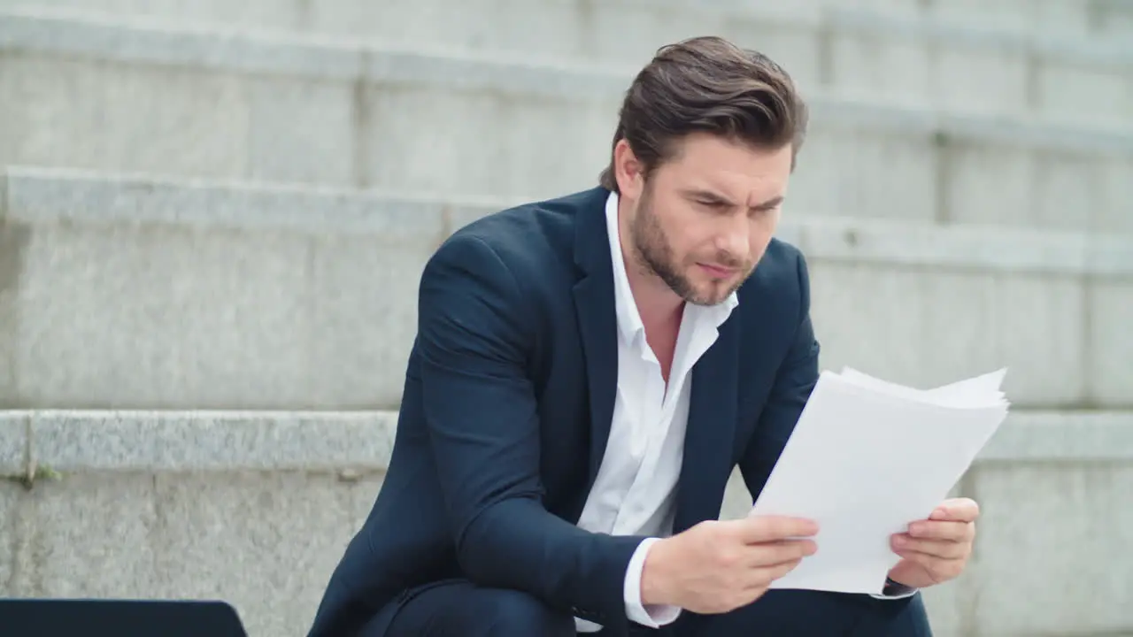 Business man working with documents on street Businessman looking at graphs