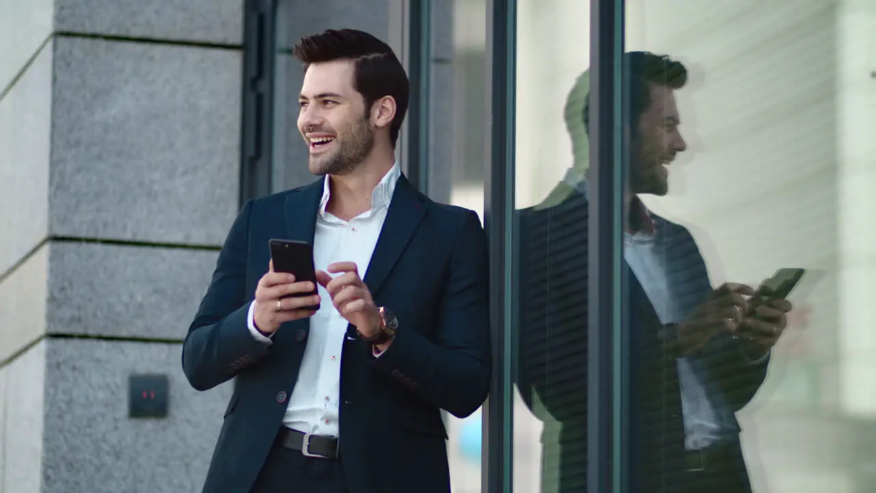 Closeup man standing in black suit at street Businessman using smartphone