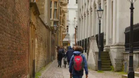 Tracking Shot Following Pedestrians Up Quaint Old English Street 