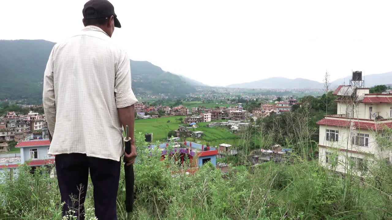 Kathmandu Nepal September 29 2019 An old Nepali man getting angry with his grazing sheep down over a hillside in Kathmandu Nepal on September 29 2019