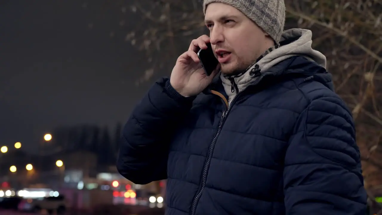 Man receives a serious phone call standing outdoors in the city handheld view with copy space