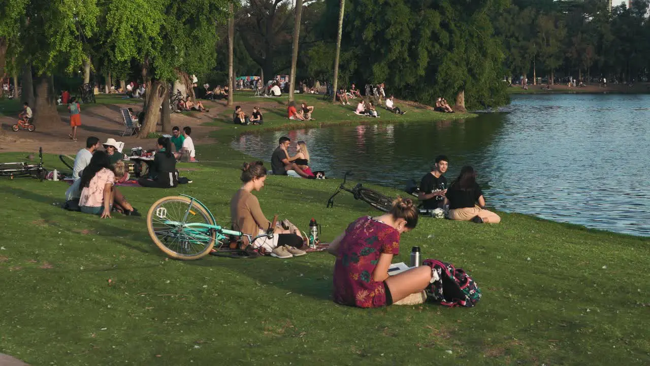 people relaxing in the park by the lake on a beautiful day