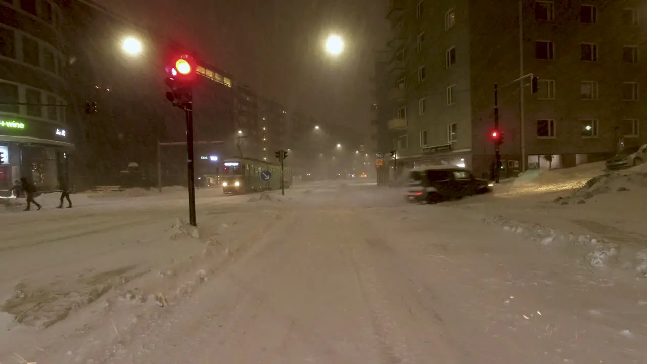 POV static shot waiting at traffic lights with pedestrians crossing in the Snow-storm