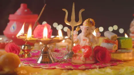 Five Wick Lamp And Statue Of Ganesh On Decorated Table Celebrating Festival Of Diwali