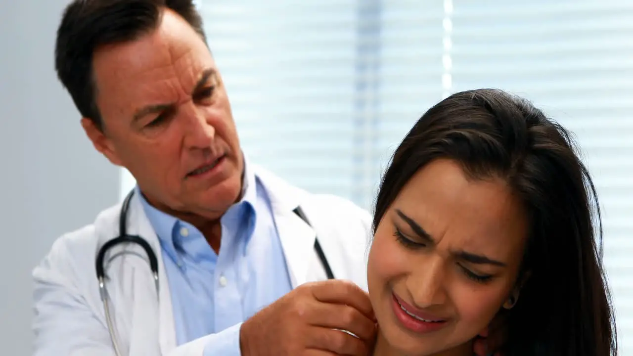 Doctor examining female patients neck