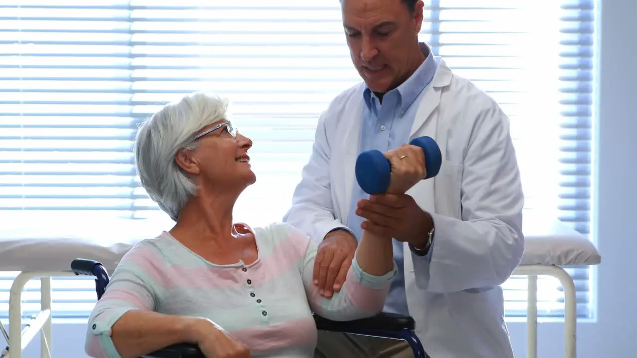 Physiotherapist assisting senior patient with hand exercise