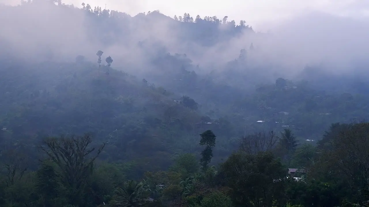 Low cloud drifts through jungle village on mountain side in Guatemala