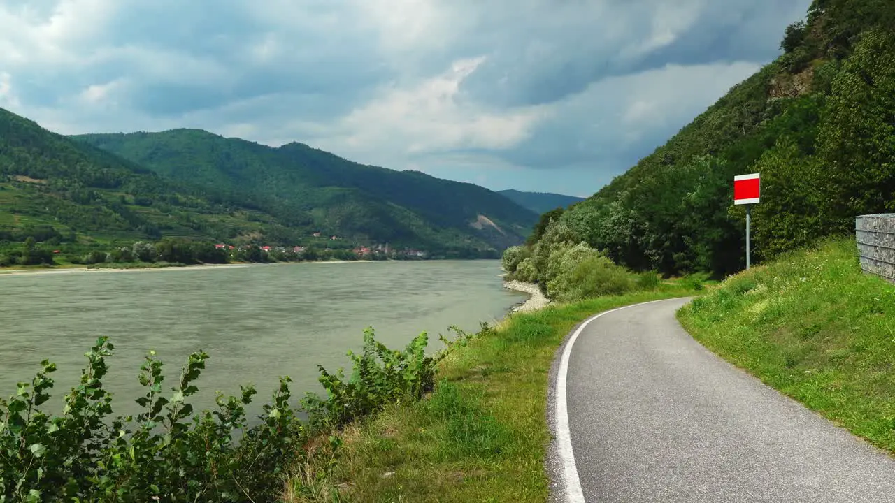 Two Cyclists Pass By Bicycle Trail near The Danube River