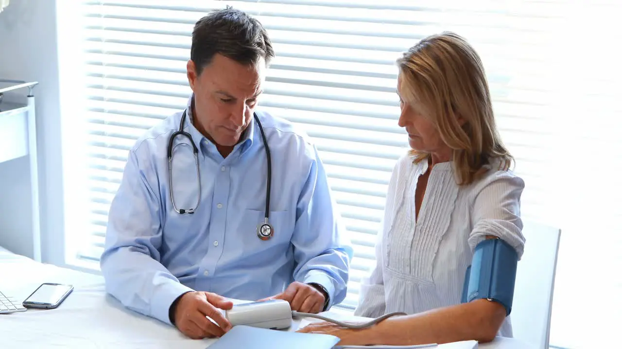 Doctor interacting with patient while checking blood pressure