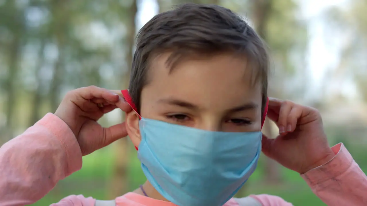 Teen boy wearing medical mask outdoors Young guy protecting from covid19