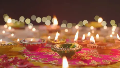 Person Putting Burning Diya Lamp Onto Table Decorated To Celebrate Festival Of Diwali 1