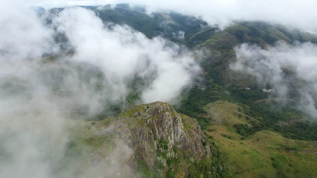 Drone shot flying through clouds above mountain peaks in African nature