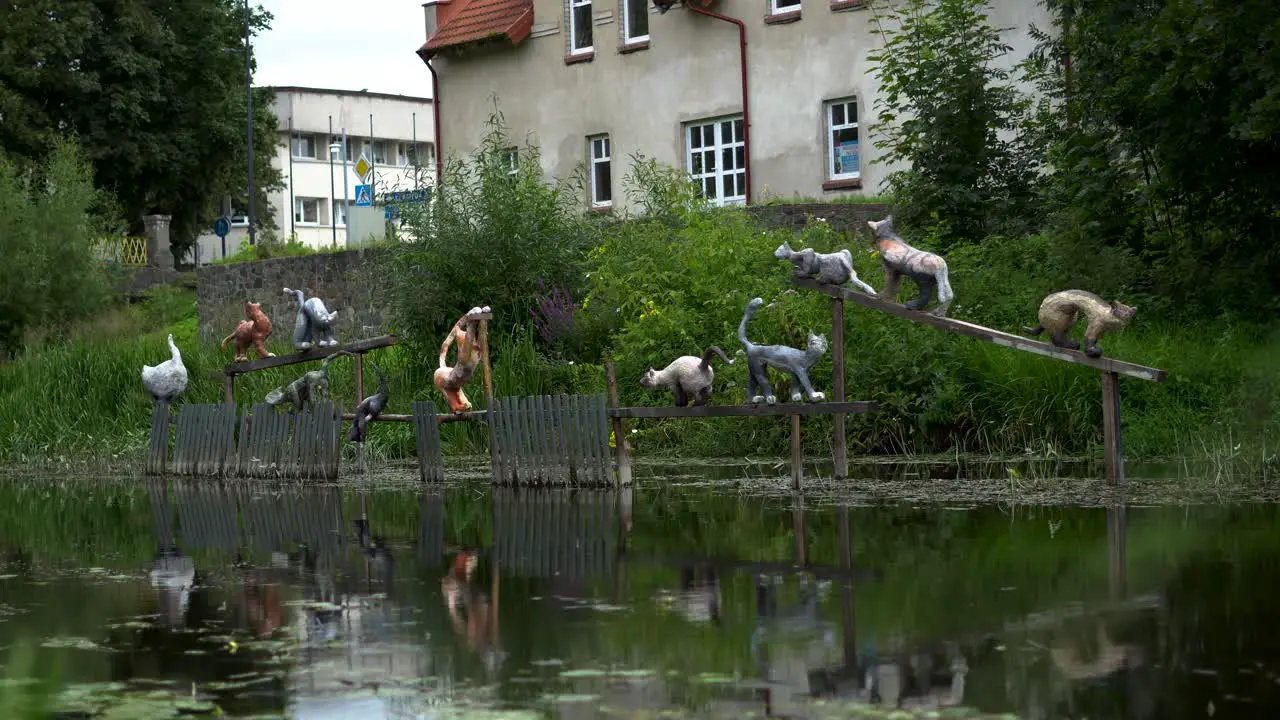 Artistic Sculpture of cats placed over the river on the fence