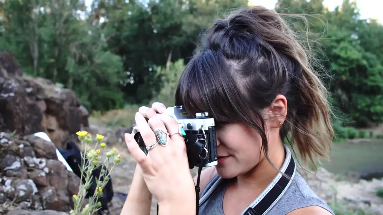 Handheld footage of a cute hipster girl talking and messing around with a camera