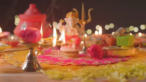 Person Holding Five Wick Lamp And Statue Of Ganesh On Decorated Table Celebrating Festival Of Diwali 1