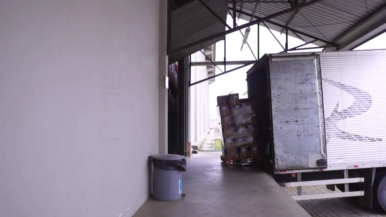 A man loading up a pallet on a docked truck