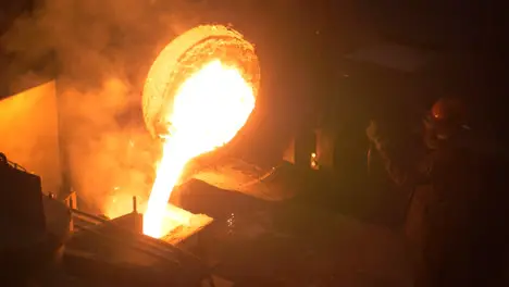 Industrial worker casting metal at metallurgical factory Molding molten metal