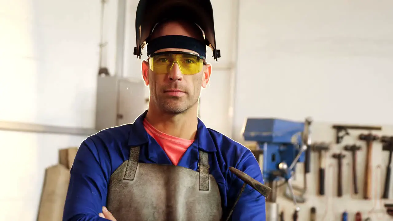 Portrait of male welder standing with arms crossed