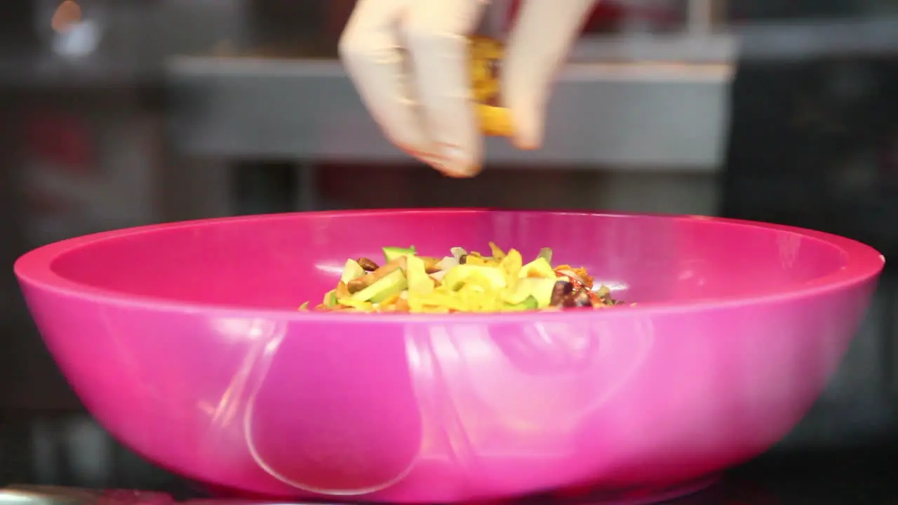 Caterer preparing salad with nachos