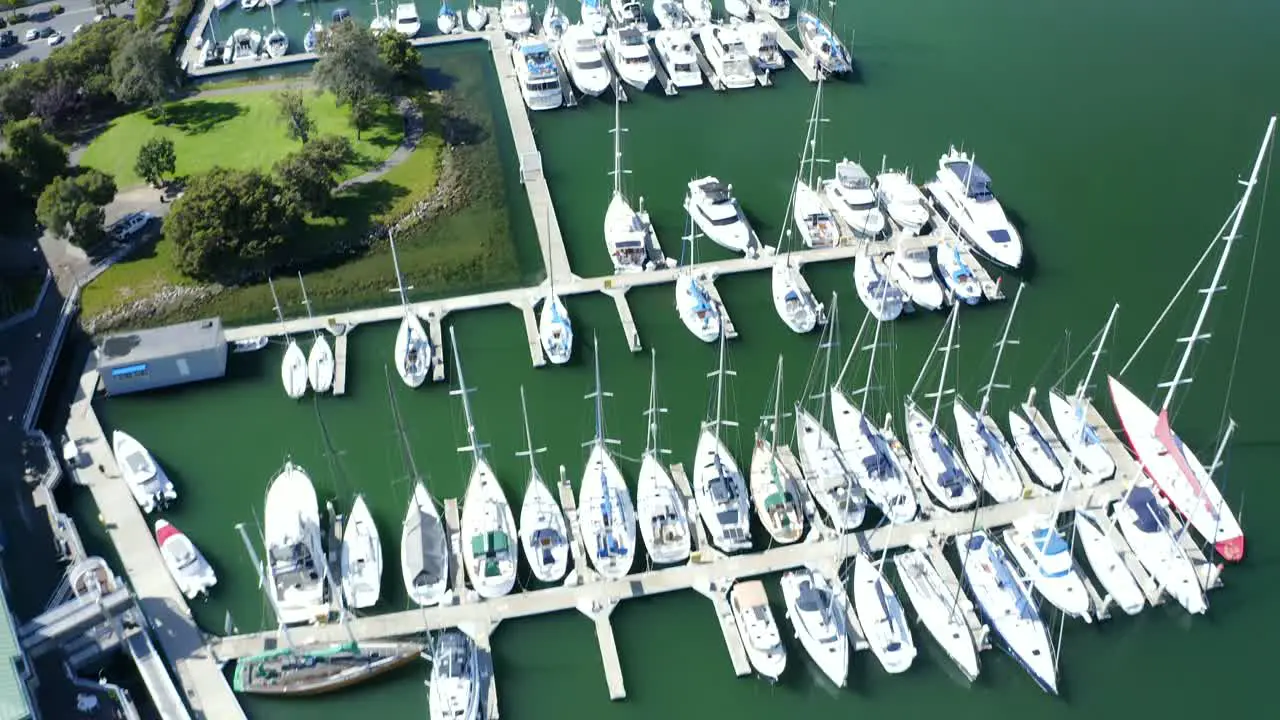 A long push forward over a beautiful marina as the camera pans up to reveal a busy city with a lot of industry