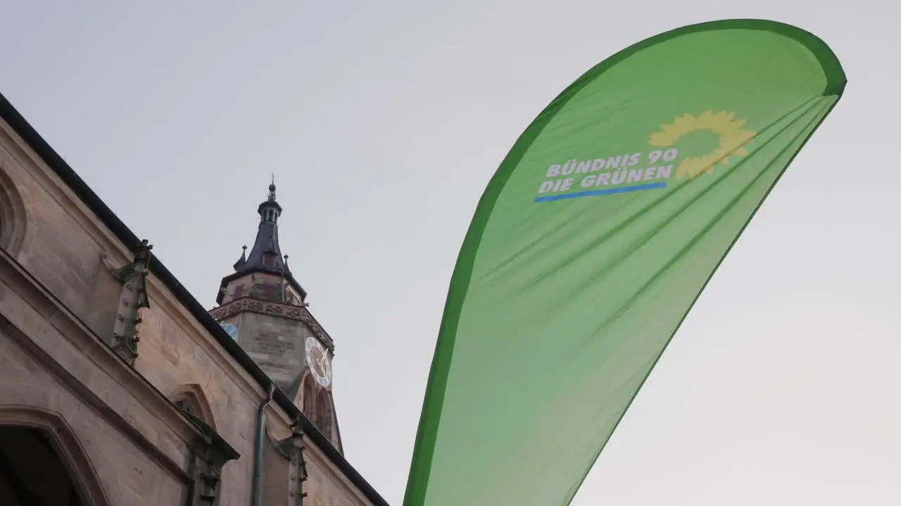 Flag of the political party Bündnis 90 Die Grünen in front of a church in Tübingen Germany