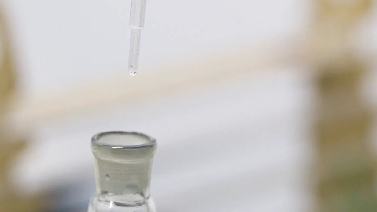 Scientist Carefully Drips Water into Test Tube in Slow Motion using an Eye Dropper for Precise Measurements