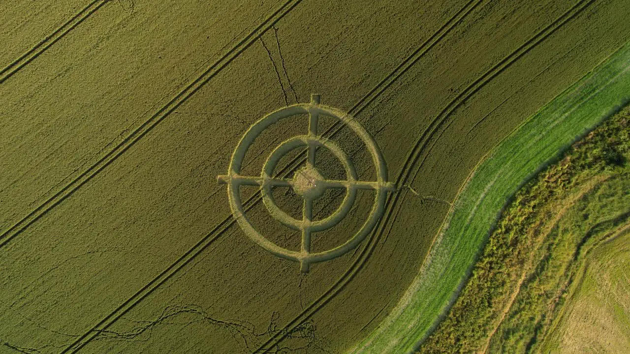 Hackpen hill strange crop circle target pattern in rural grass farming meadow aerial view descending above harvest