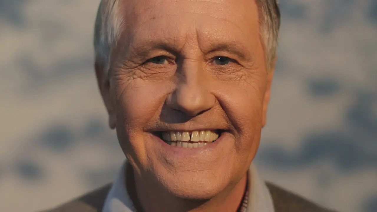 Close Up Of The Retired Senior Man Turning His Head To The Camera And Smiling Sincerely