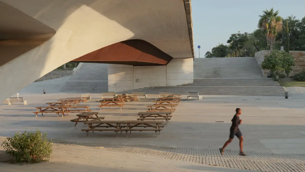 Male Athlete In Sportswear Running And Exercising In A City Park