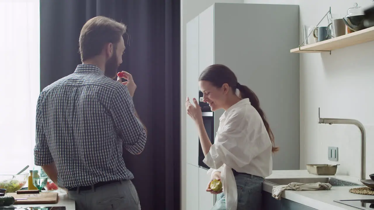 Laughing Couple Chatting And Having Fun In A Modern Style Kitchen