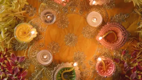 Overhead Turntable Shot Of Lit Diya Lamps On Table Decorated For Festival Of Diwali